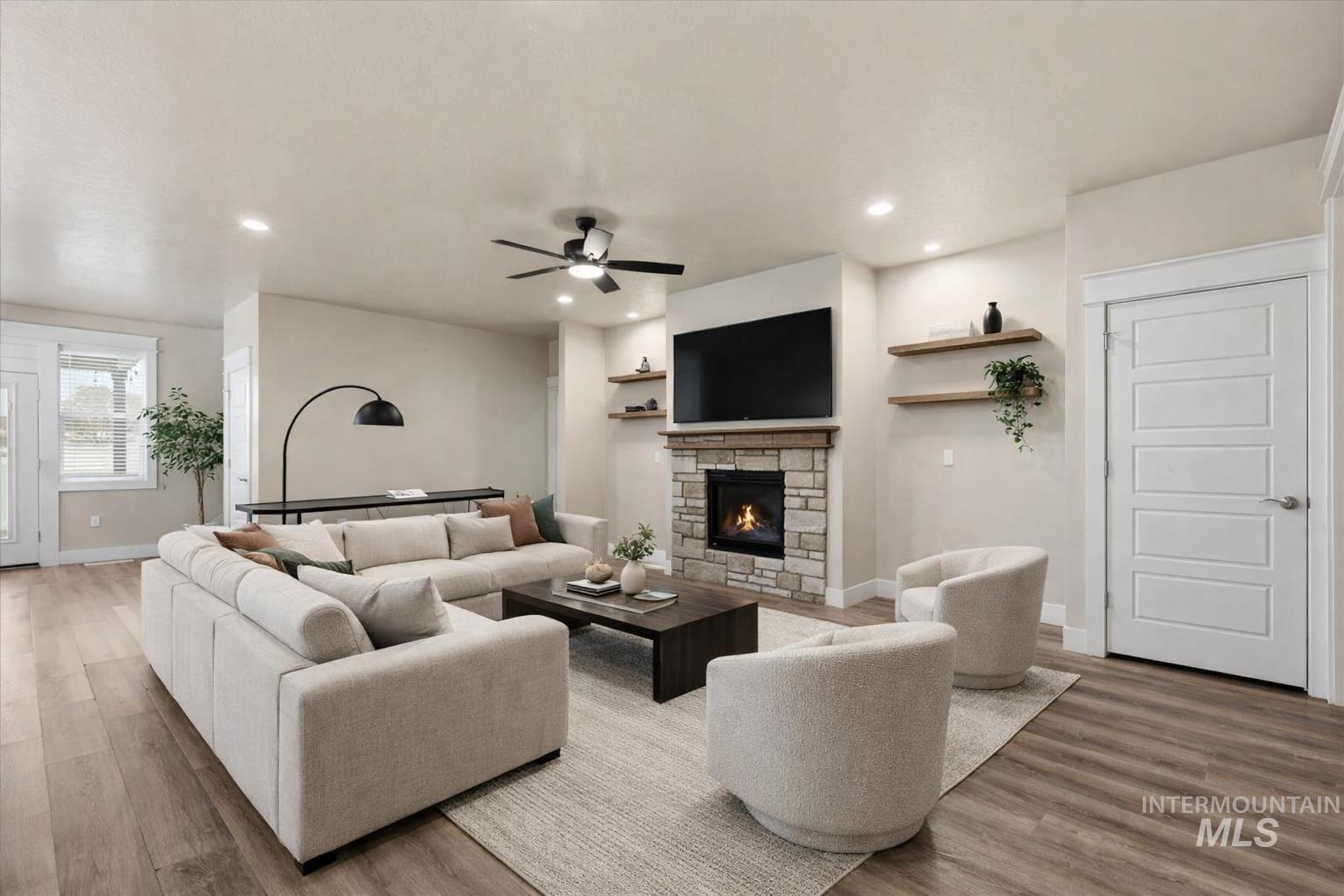 92 South Ravine Way Nampa, ID 83687 - Photo 11 of 29 Living area featuring ceiling fan, a stone fireplace, light wood-style floors, and recessed lighting