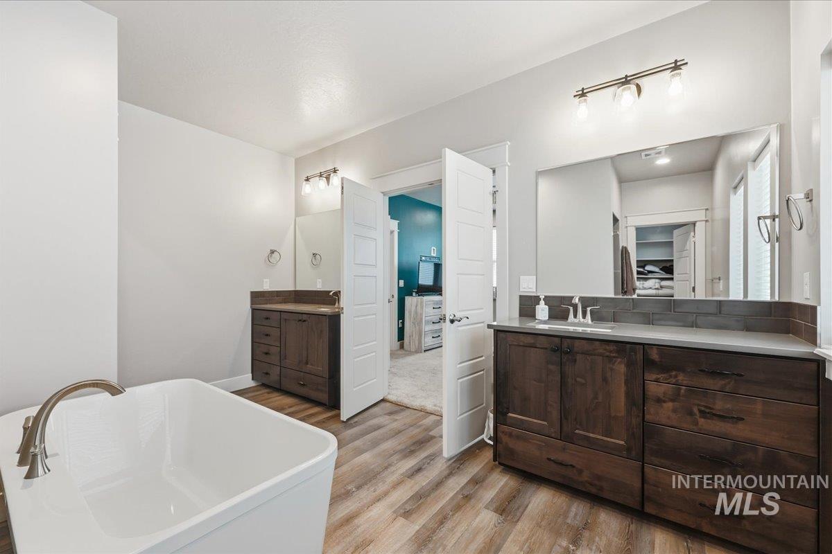 92 South Ravine Way Nampa, ID 83687 - Photo 14 of 29 Bathroom with two vanities, a soaking tub, ensuite bathroom, and light wood finished floors