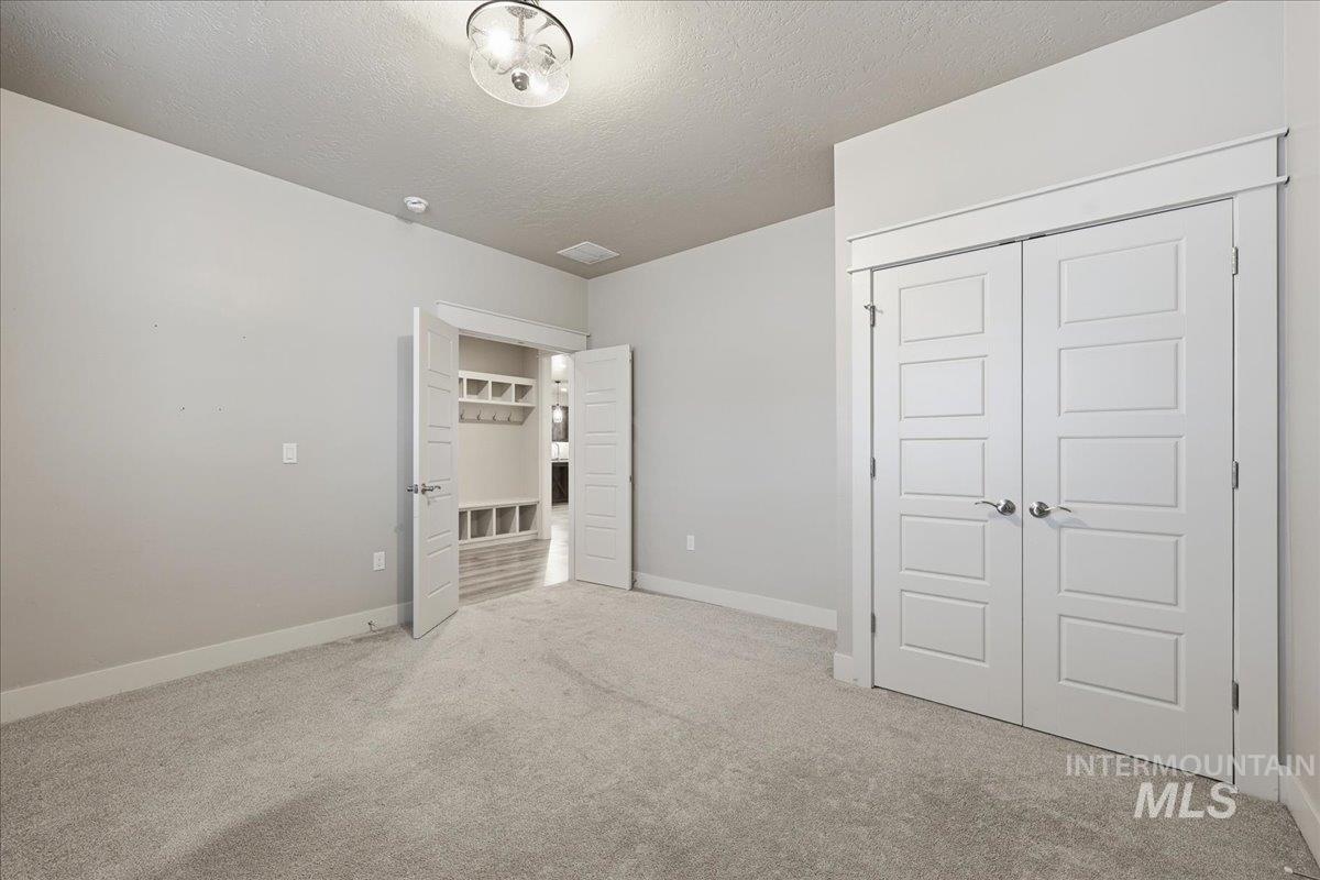 92 South Ravine Way Nampa, ID 83687 - Photo 15 of 29 Unfurnished bedroom featuring a textured ceiling, light carpet, and a closet