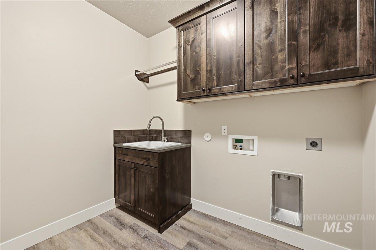 92 South Ravine Way Nampa, ID 83687 - Photo 18 of 29 Laundry area featuring cabinet space, hookup for a washing machine, hookup for an electric dryer, light wood-type flooring, and gas dryer hookup