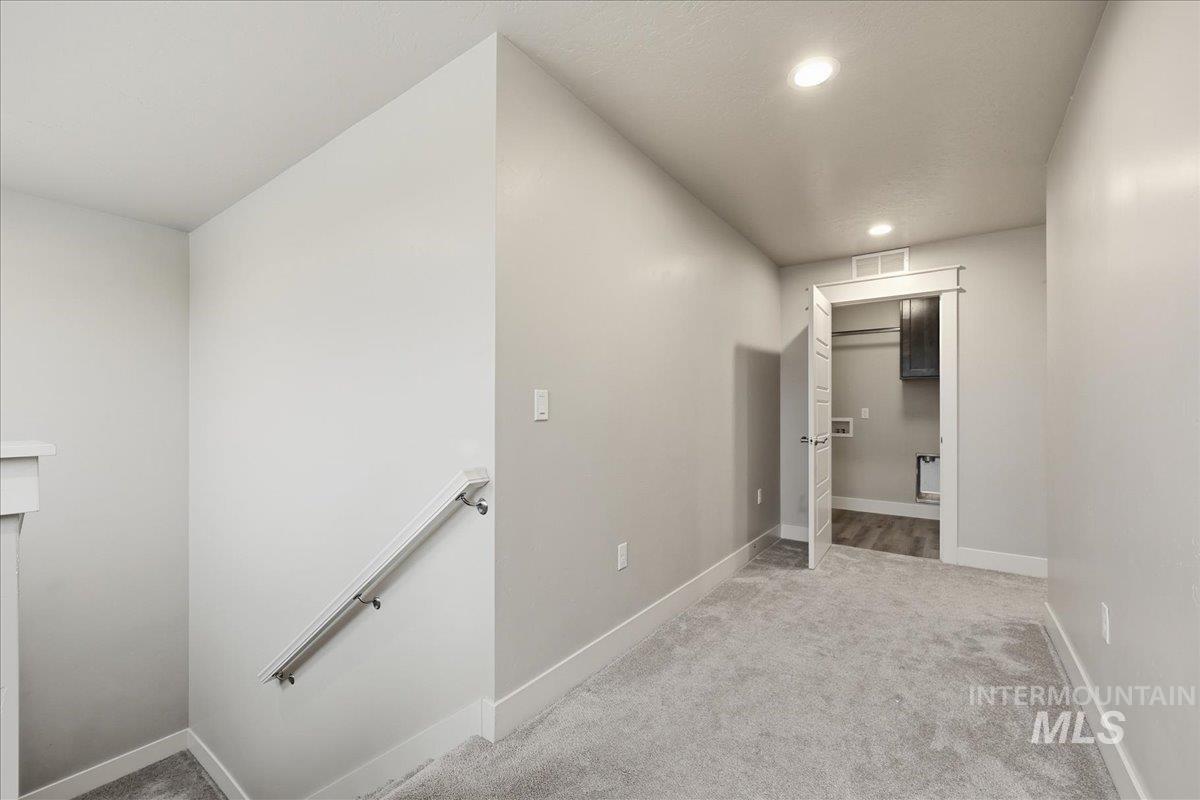92 South Ravine Way Nampa, ID 83687 - Photo 19 of 29 Hallway featuring light carpet, an upstairs landing, and recessed lighting