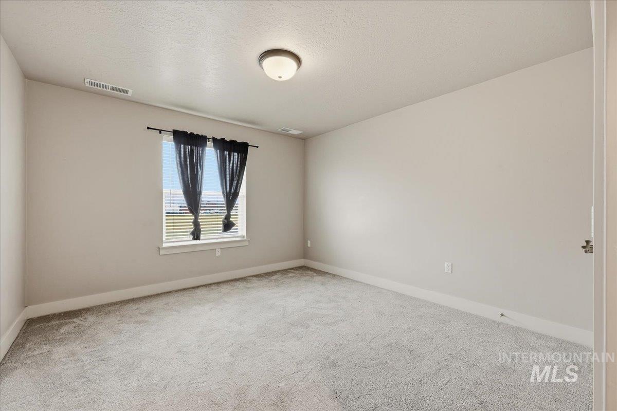 92 South Ravine Way Nampa, ID 83687 - Photo 22 of 29 Carpeted spare room with a textured ceiling and baseboards