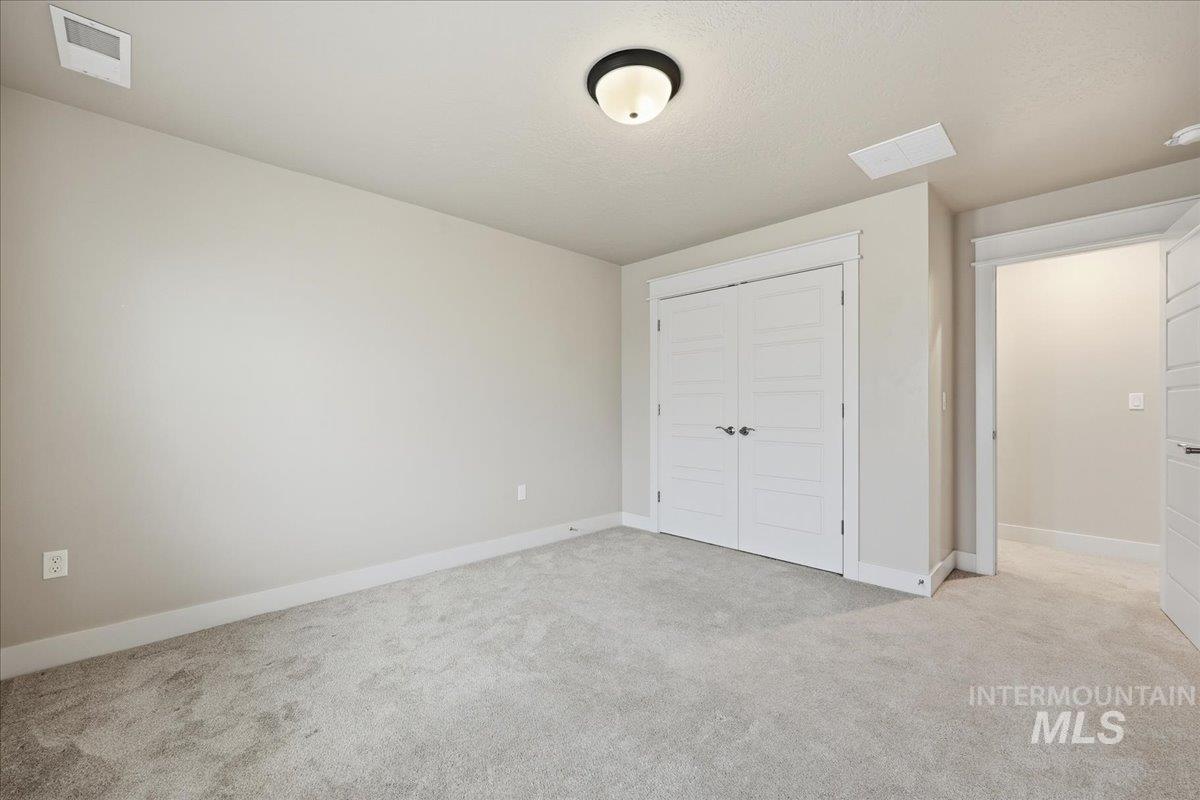 92 South Ravine Way Nampa, ID 83687 - Photo 23 of 29 Unfurnished bedroom featuring light colored carpet and a closet