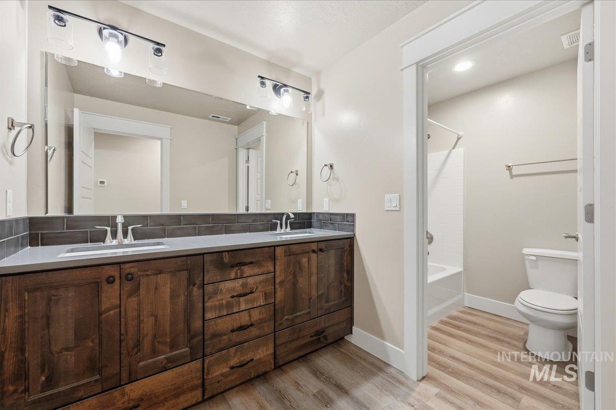 92 South Ravine Way Nampa, ID 83687 - Photo 24 of 29 Bathroom featuring double vanity, bathtub / shower combination, and light wood-type flooring