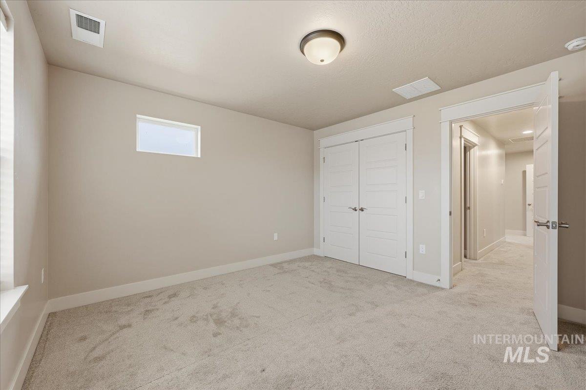92 South Ravine Way Nampa, ID 83687 - Photo 26 of 29 Unfurnished bedroom with light colored carpet and a closet