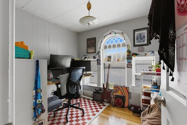 a bedroom with a bed and wooden floor