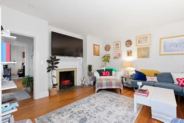 a living room with furniture a flat screen tv and a fireplace