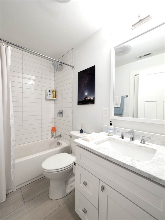 65 Border Street, Unit 4 Boston, MA 02128 - Photo 11 of 15 a bathroom with a sink a toilet and a large mirror