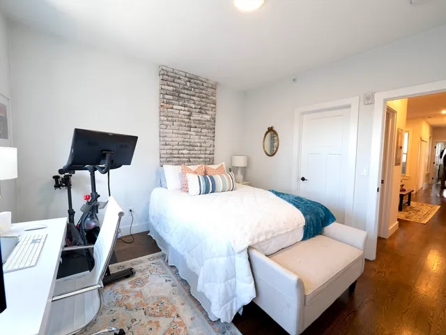 a bedroom with bed and wooden floor