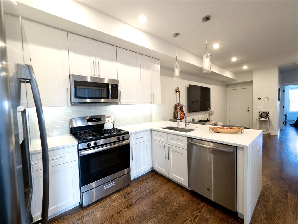 65 Border Street, Unit 4 Boston, MA 02128 - Photo 5 of 15 a kitchen with stainless steel appliances a stove sink microwave and refrigerator
