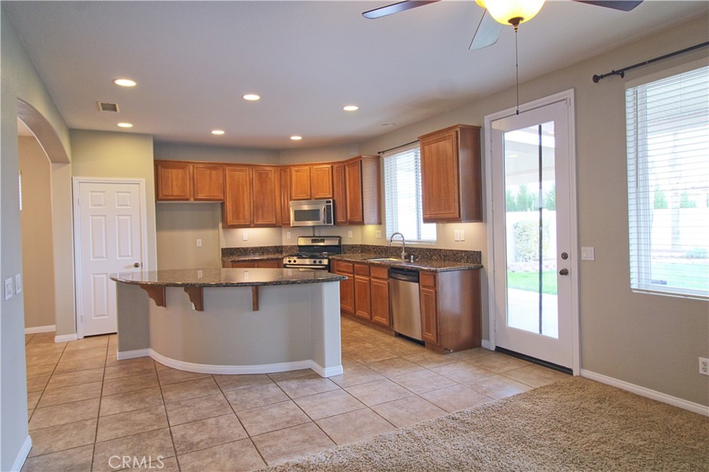 1637 Rigel Street Beaumont, CA 92223 - Photo 6 of 22 a kitchen with granite countertop a stove a sink and a refrigerator