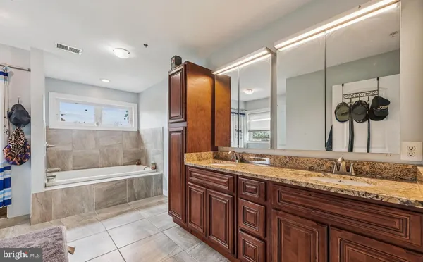 a bathroom with a granite countertop sink mirror and bathtub