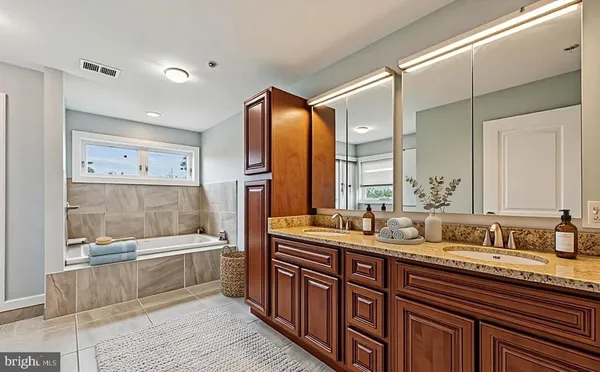 a bathroom with double vanity sinks a mirror and a shower