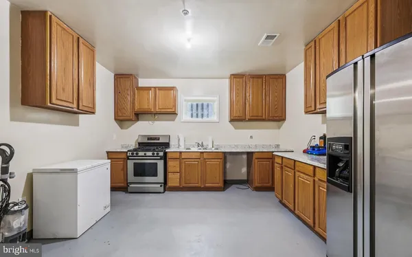 a kitchen with stainless steel appliances granite countertop a stove top oven a sink dishwasher and a refrigerator