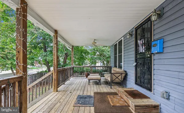 a balcony with wooden floor and outdoor seating
