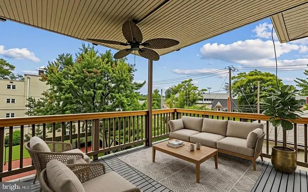 a roof deck with couches and potted plants