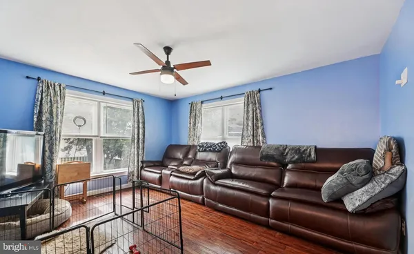 a living room with furniture a flat screen tv and a large window