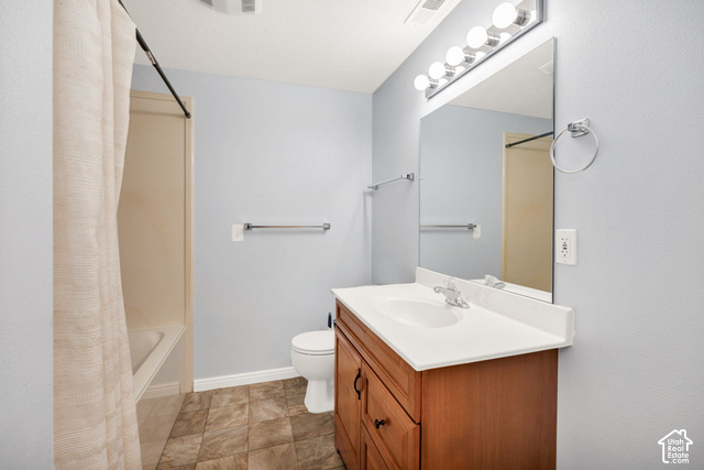 1143 East Mountain Road Logan, UT 84321 - Photo 37 of 64 Bathroom featuring a wood-finish vanity with a white countertop, large wall mirror, and tile flooring