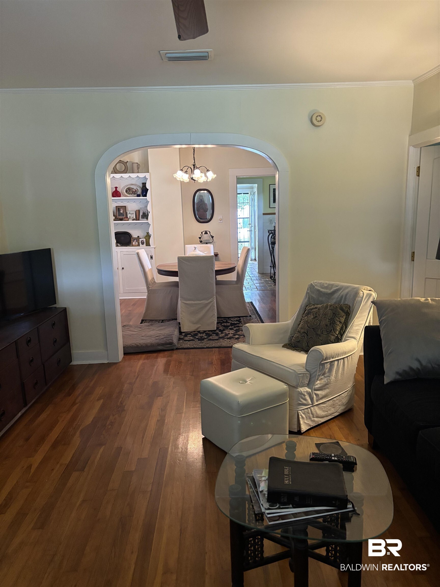 216 West Orange Avenue Foley, AL 36535 - Photo 34 of 37 Living room with arched walkways, a chandelier, wood finished floors, crown molding, and baseboards