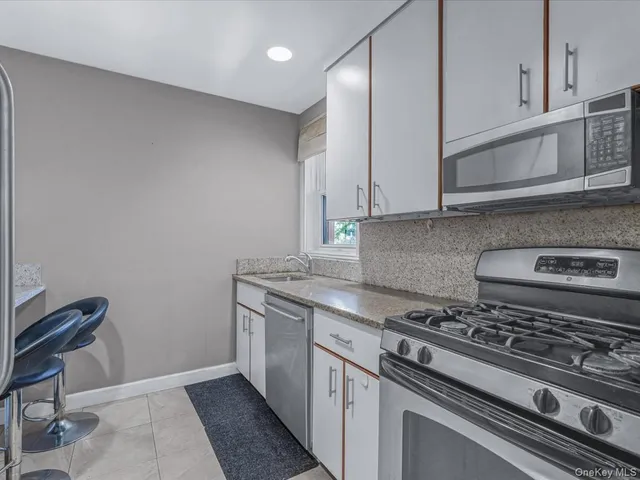 a kitchen with granite countertop a stove and a sink