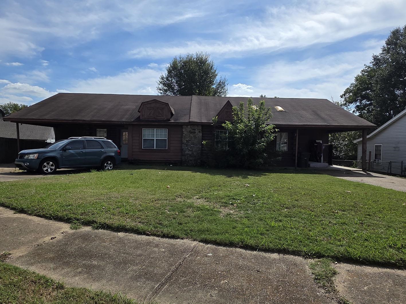 Single story home with a carport, a front lawn, and concrete driveway