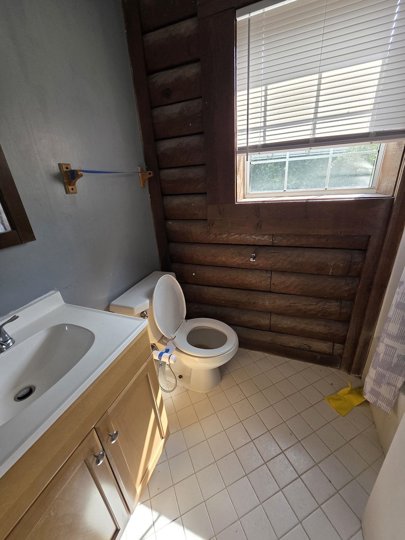 6521 Wimble Road Memphis, TN 38134 - Photo 16 of 18 Bathroom featuring vanity, rustic walls, and light tile patterned floors