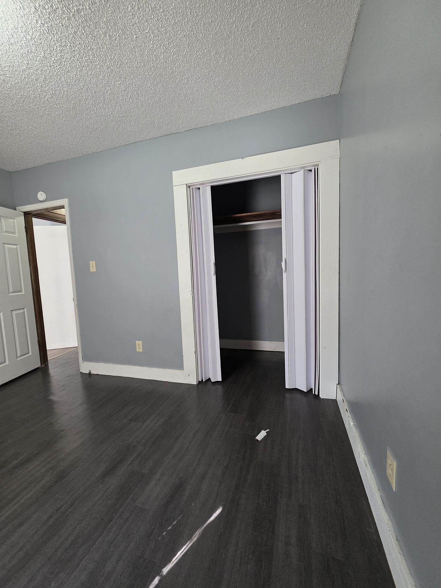 6521 Wimble Road Memphis, TN 38134 - Photo 10 of 18 Unfurnished bedroom with a textured ceiling, dark wood finished floors, and a closet