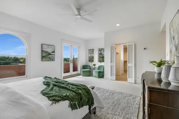 a bedroom with a bed mirror and window