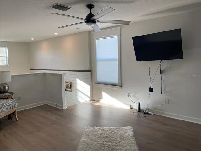 a view of a porch with furniture and wooden floor