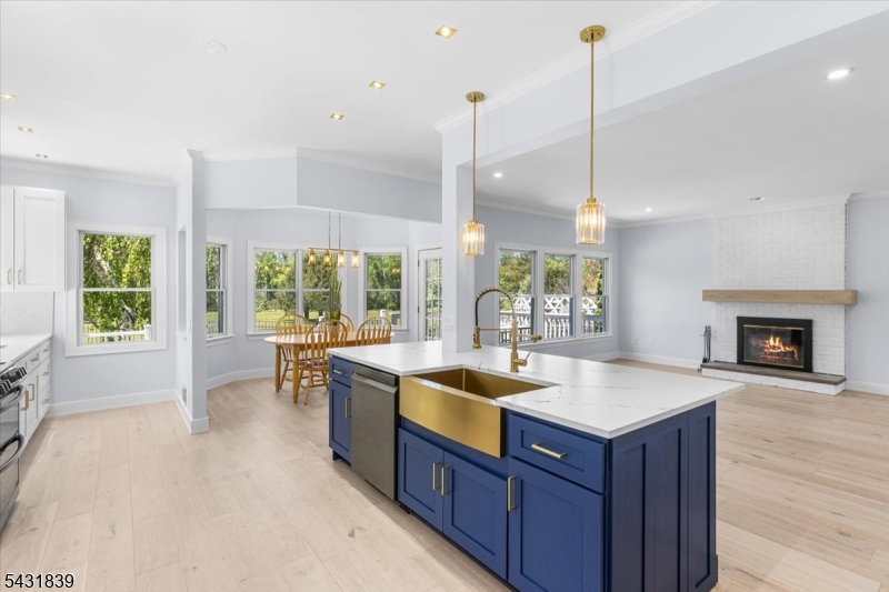 15 Spring Hunter Court Andover, NJ 07821 - Photo 16 of 49 a open kitchen with a sink a oven a dining table and chairs with wooden floor