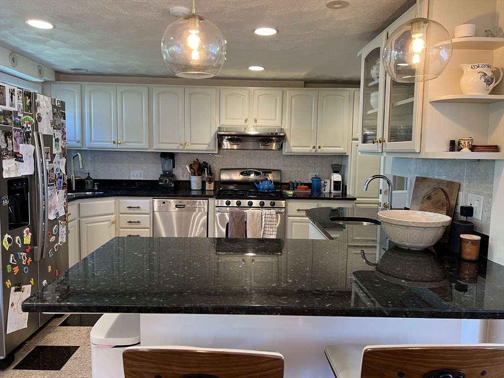 11 Garrison Road, Unit 1 Arlington, MA 02474 - Photo 6 of 42 a kitchen with stainless steel appliances granite countertop a stove a sink and a microwave