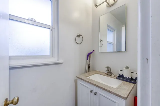 a bathroom with a granite countertop sink and a mirror