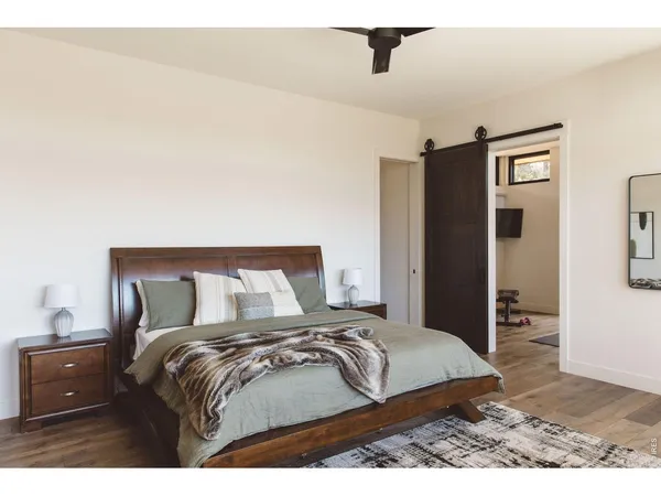 a bedroom with a bed and wooden floor