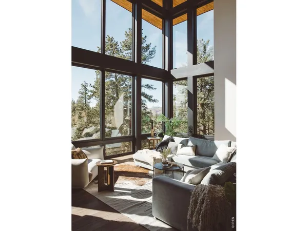 a living room with furniture and floor to ceiling windows