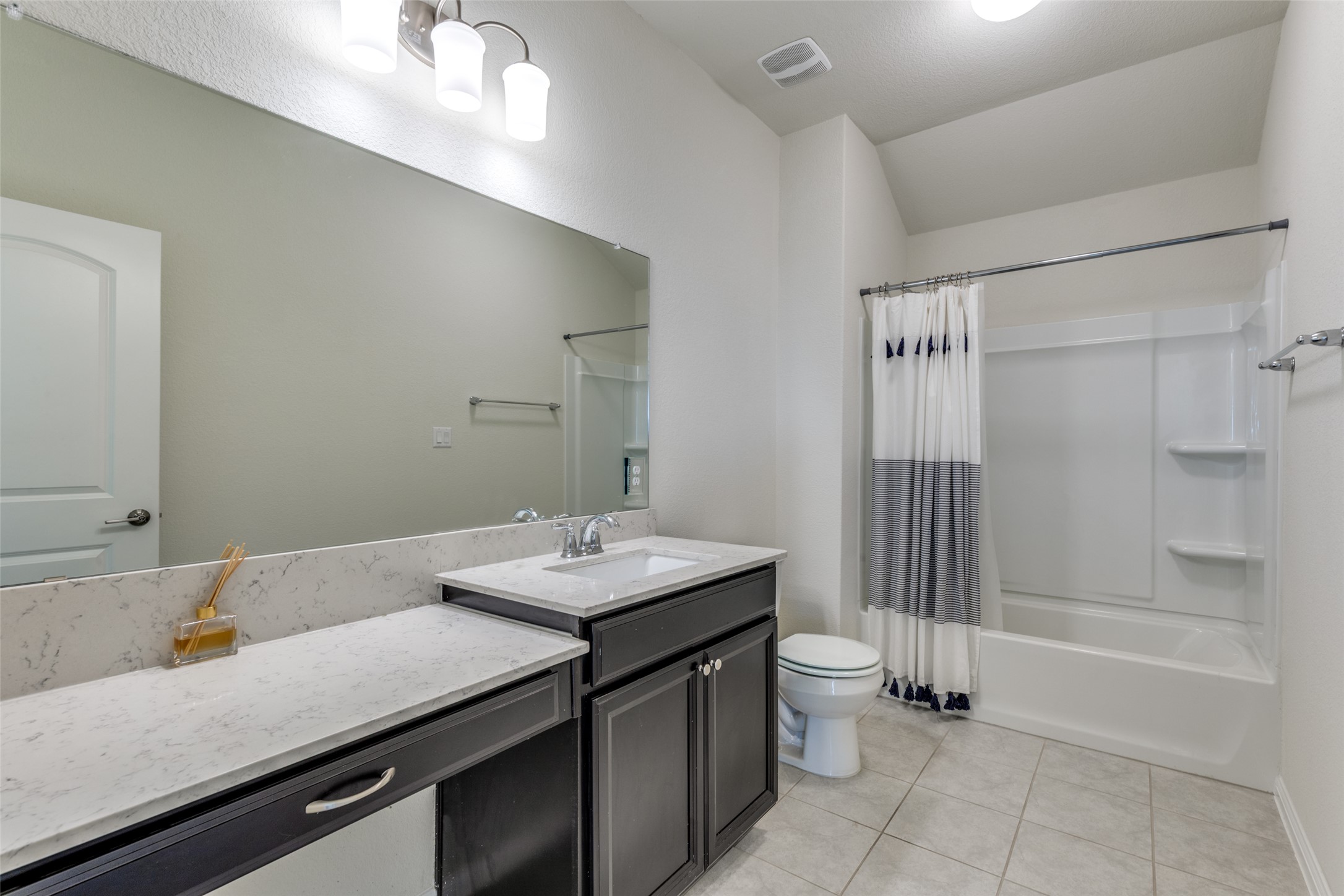 3208 Maysillee Street Austin, TX 78728 - Photo 14 of 23 Bathroom featuring shower / tub combo, vanity, and light tile floors