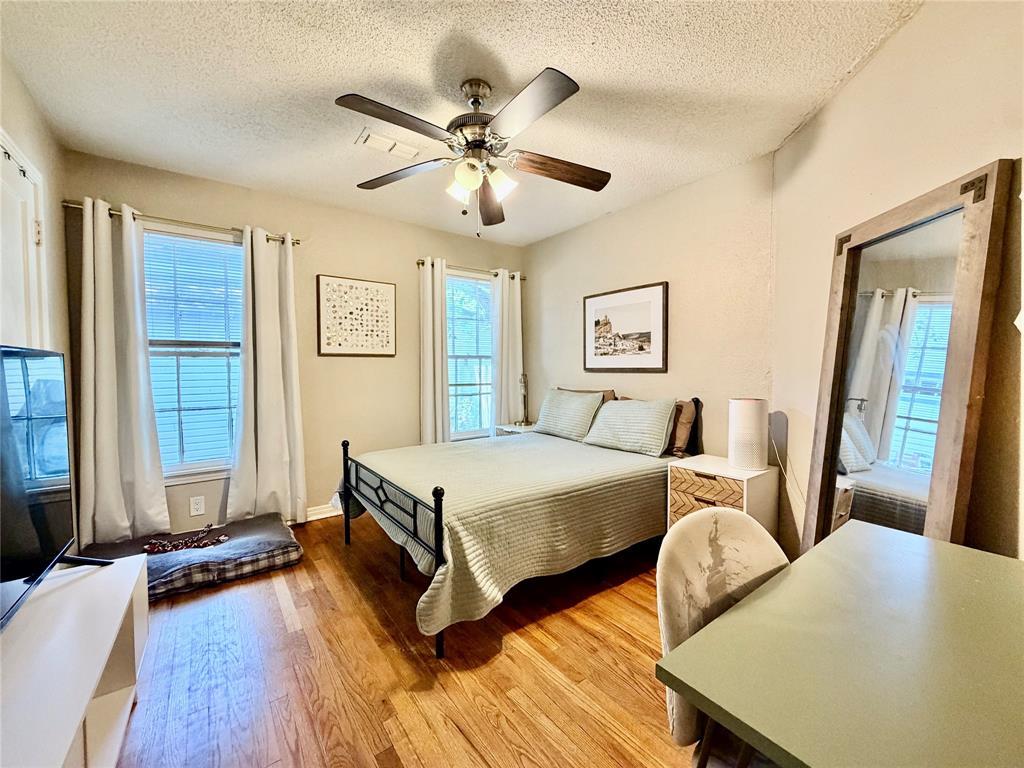 919 Denton Street Denton, TX 76201 - Photo 10 of 19 a spacious bedroom with two beds and wooden floor