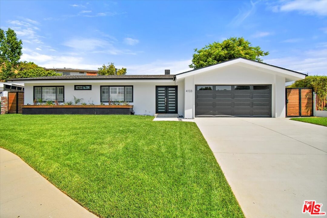 a front view of a house with a garden and yard