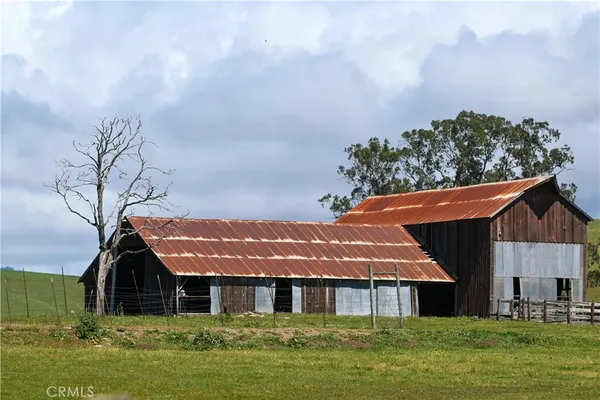 a front view of house with yard and trees in the background