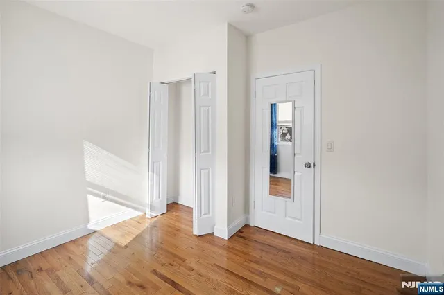 a view of a hallway with wooden floor and entryway