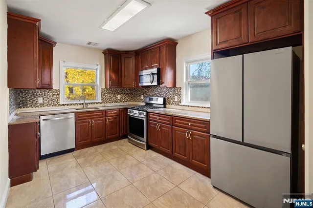 a kitchen with stainless steel appliances granite countertop a refrigerator sink and cabinets