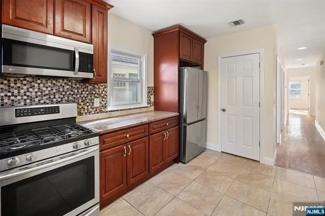 a kitchen with stainless steel appliances granite countertop a stove a microwave and a sink