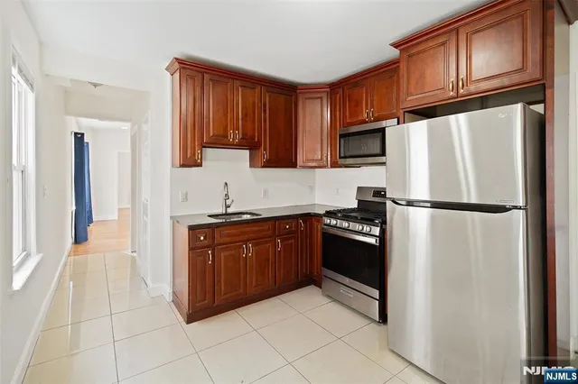 a kitchen with stainless steel appliances granite countertop a refrigerator stove top oven and sink