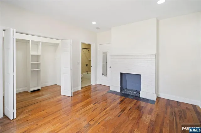 an empty room with wooden floor and a fireplace