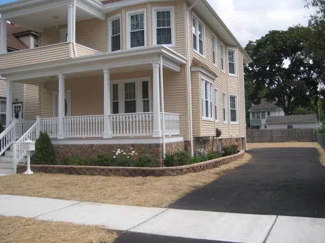 a view of a house with a small yard and wooden fence