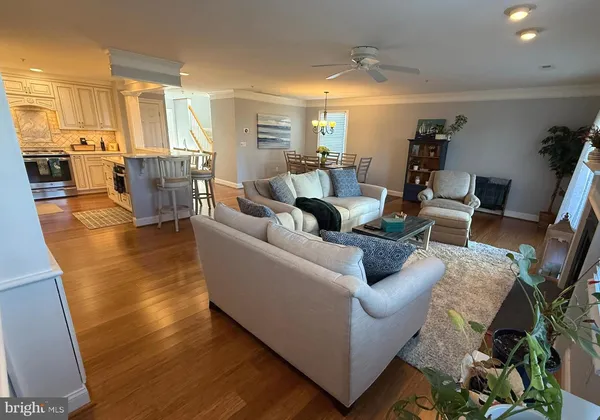 a dining room with stainless steel appliances kitchen island granite countertop furniture and wooden floor