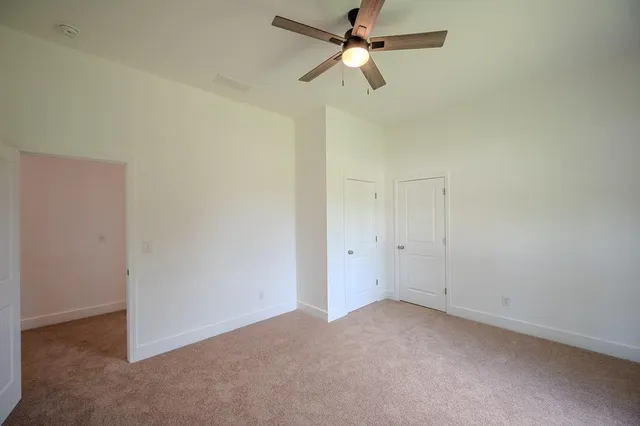 an empty room with a fan and a fan