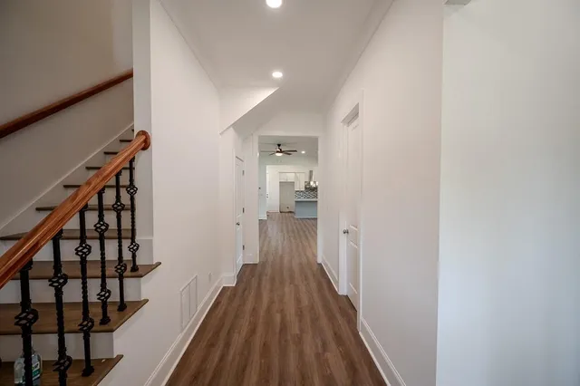 a view of a hallway with wooden floor and staircase