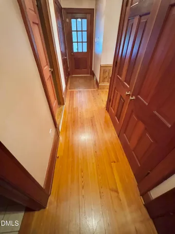 a kitchen with stainless steel appliances a stove a refrigerator a sink a dining table and chairs with wooden floor