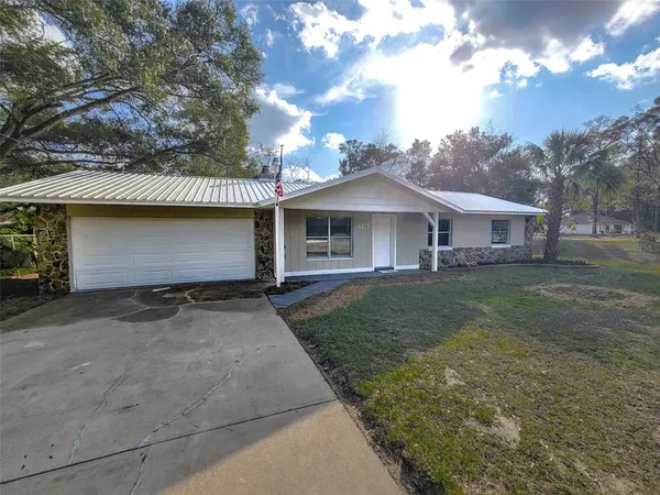 a front view of a house with a garden and yard