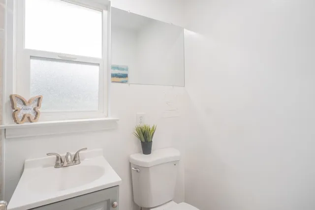 a bathroom with a sink a toilet and a mirror